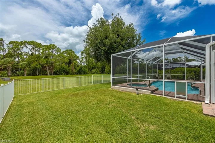 View of yard featuring glass enclosure and a fenced in pool