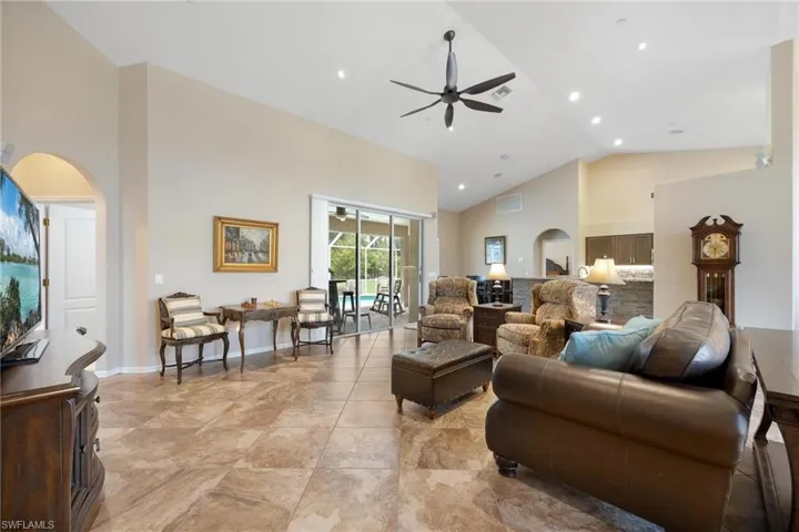Tiled living room with high vaulted ceiling and ceiling fan