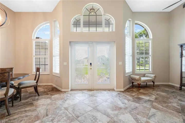 Tiled foyer featuring a high ceiling and french doors