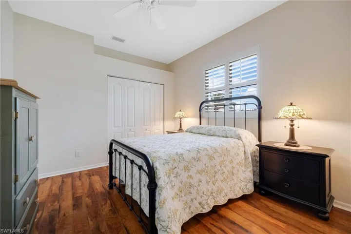 Bedroom with ceiling fan, a closet, and dark hardwood / wood-style flooring