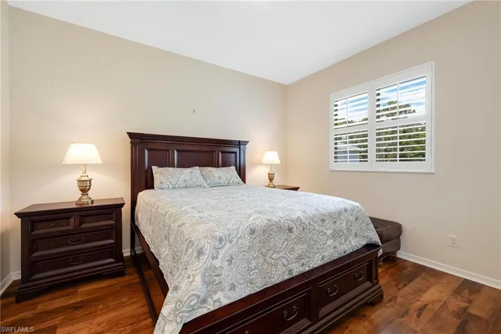 Bedroom with dark hardwood / wood-style flooring