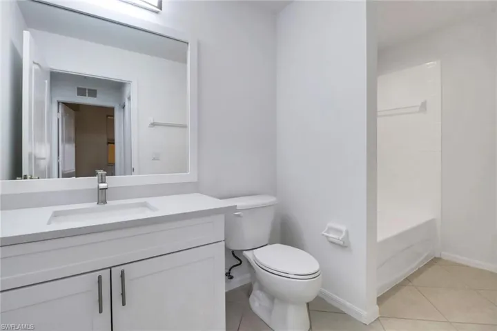 Full bathroom with tile patterned floors, vanity, shower / washtub combination, and toilet