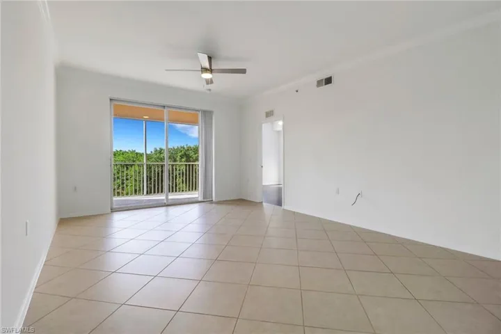 Tiled empty room with crown molding and ceiling fan