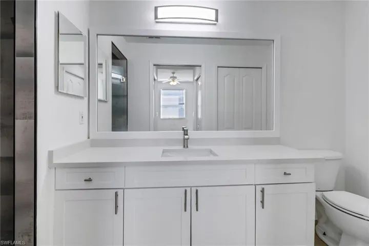 Bathroom featuring vanity, ceiling fan, and toilet