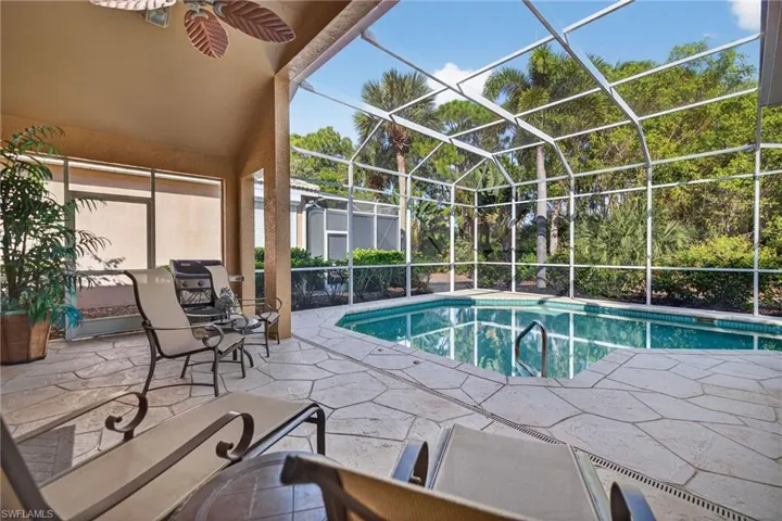 Swimming pool with a sunroom, a patio, and glass enclosure