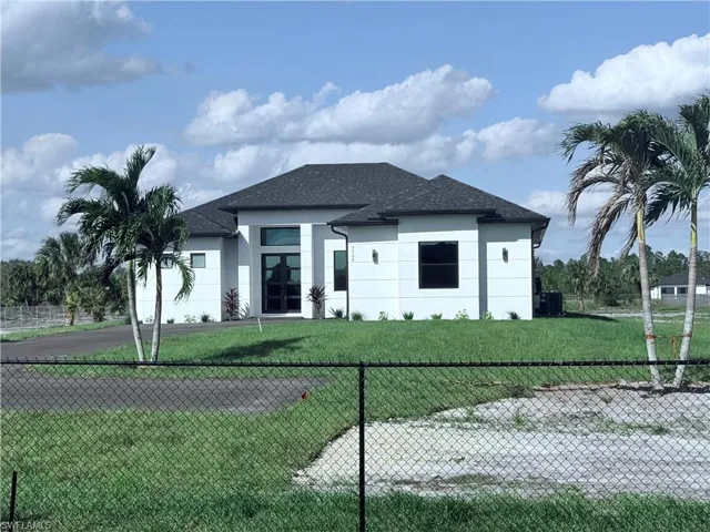 Prairie-style house featuring cooling unit and a front lawn