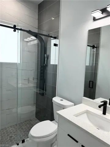 Bathroom with walk in shower, vanity, and toilet