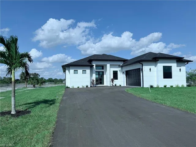 View of front of home featuring a front lawn and a garage