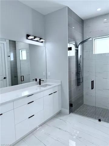 Bathroom with a shower with shower door and vanity