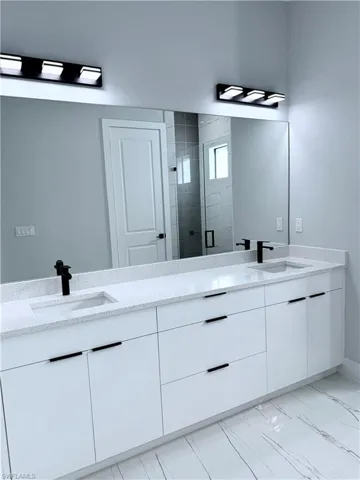 Bathroom featuring a shower with shower door and vanity
