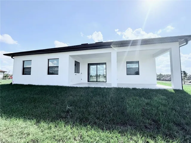 Back of house with a yard and a patio area