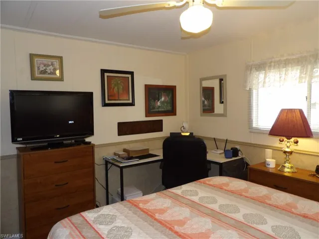 Bedroom with ceiling fan and ornamental molding