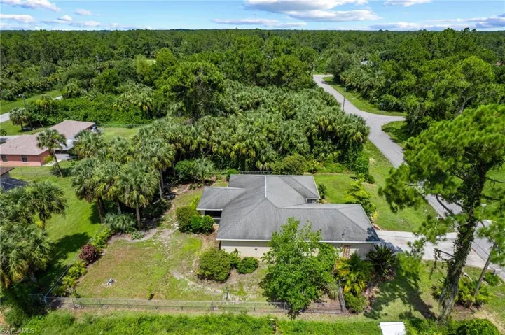 Aerial view of property and surrounding area featuring a forest