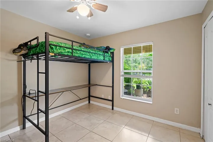Unfurnished bedroom featuring light tile patterned floors, a closet, and ceiling fan