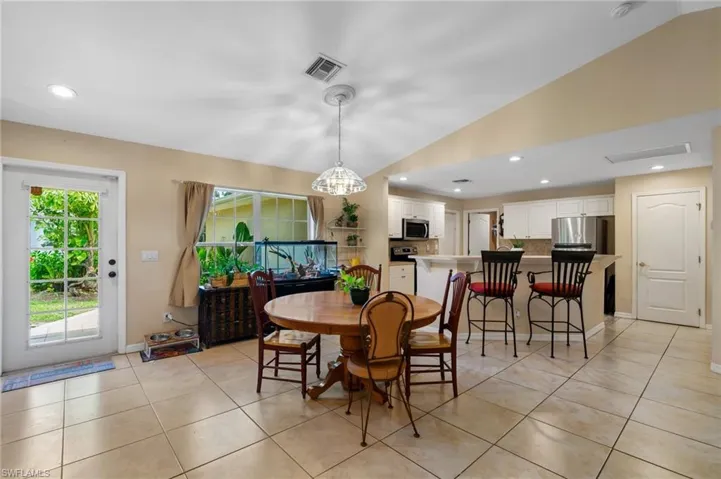 Dining room with lofted ceiling, recessed lighting, and light tile patterned floors