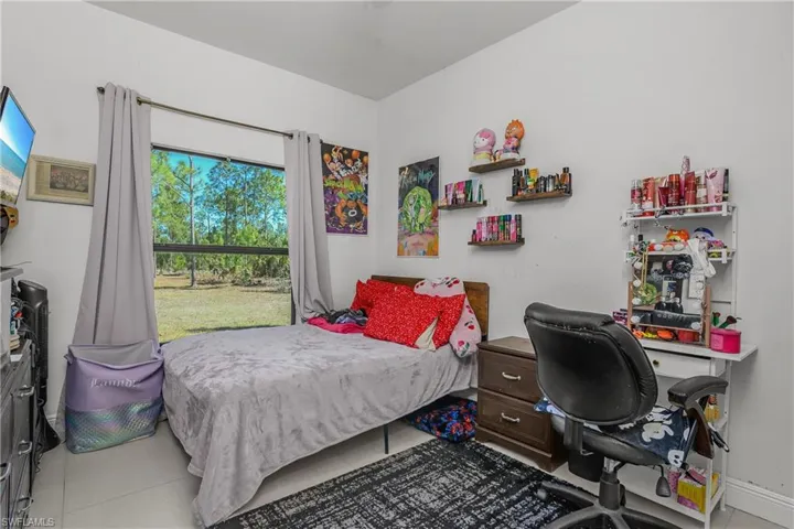 Bedroom with an office area and light tile patterned floors