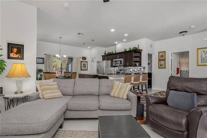 Living area with light tile patterned flooring and a chandelier