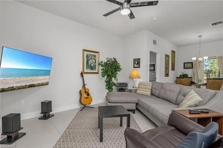 Tiled living room with hanging lights and a ceiling fan