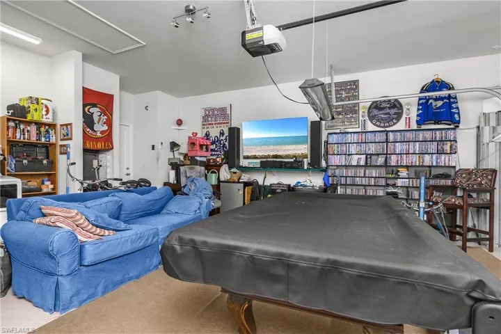 Rec room with a garage, billiards table, and carpet