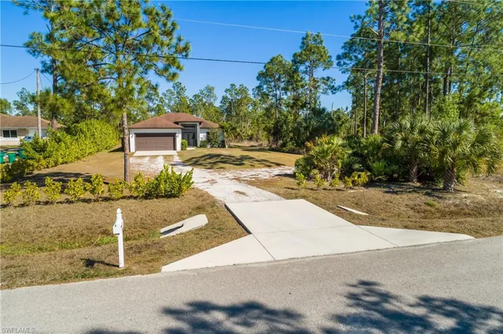 View of front of property featuring driveway and a front yard