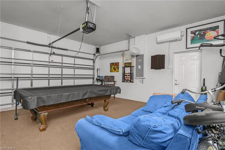 Recreation room with a garage, pool table, and electric panel