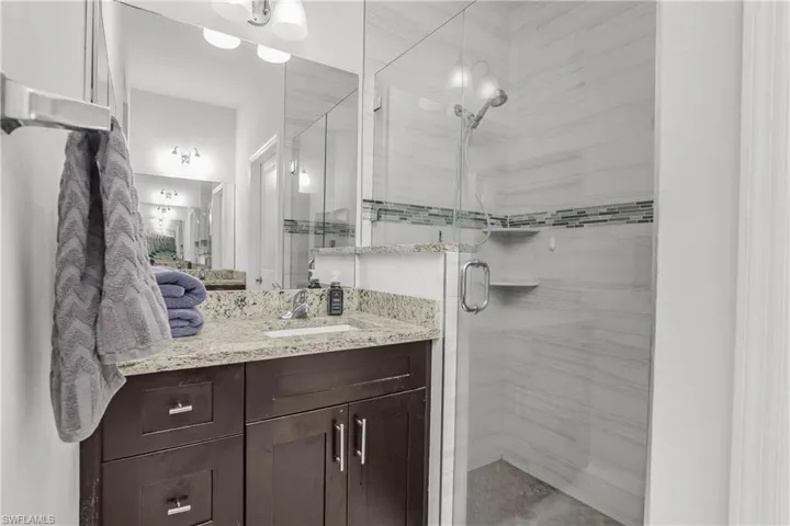 Full bathroom with vanity and a stall shower