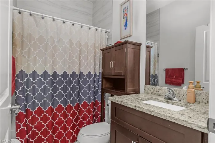 Full bath with vanity and a shower with shower curtain