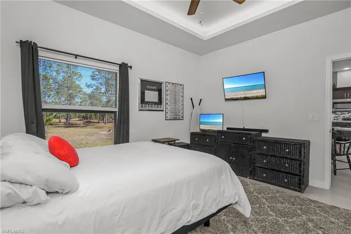 Bedroom featuring a ceiling fan, multiple windows, and carpet floors