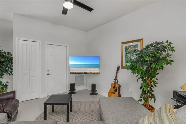 Living room with light tile patterned flooring and a ceiling fan
