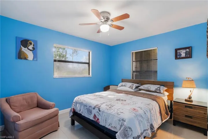 Tiled bedroom featuring ceiling fan