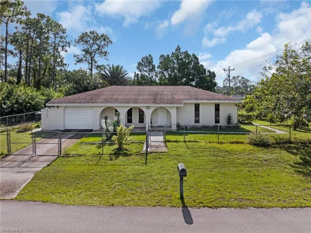 View of front facade featuring a garage and a front lawn
