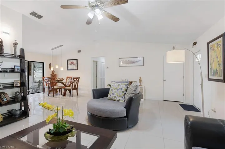 Living room with light tile patterned flooring and ceiling fan