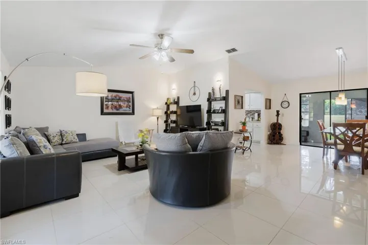 Tiled living room featuring lofted ceiling and ceiling fan