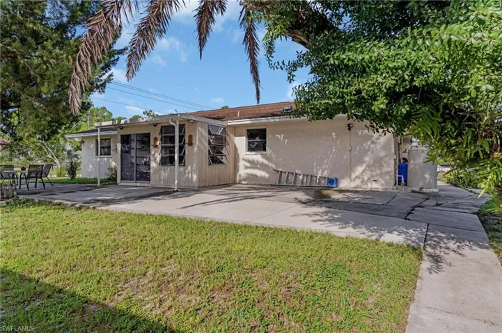Back of property with a patio and a lawn