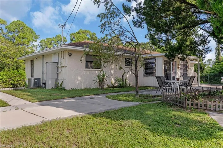 View of front of house with central AC and a front lawn