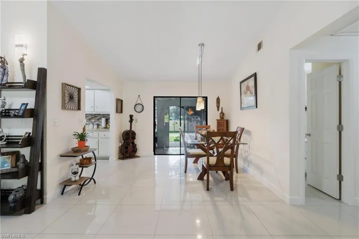 Tiled dining space featuring lofted ceiling