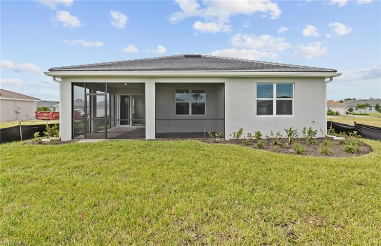 Back of house with a sunroom and a yard