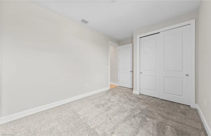 Unfurnished bedroom with carpet and a closet