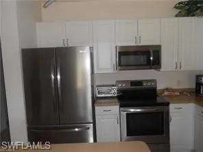 Kitchen featuring appliances with stainless steel finishes and white cabinets