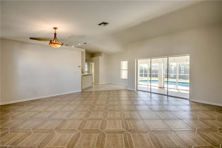 Empty room with baseboards and vaulted ceiling