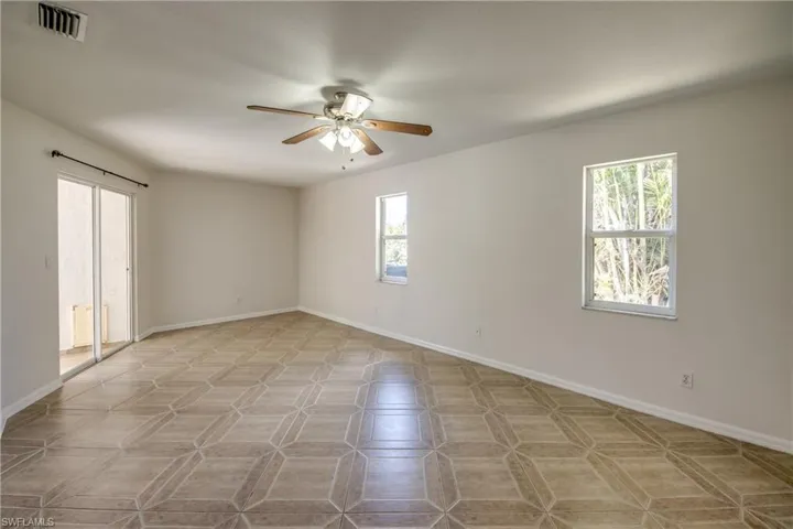 Unfurnished room with a ceiling fan and healthy amount of natural light