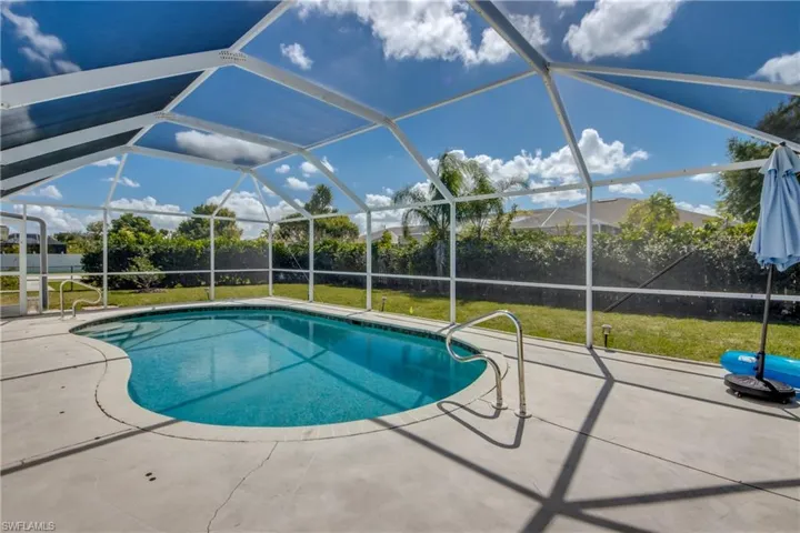 Outdoor pool with a sunroom, glass enclosure, and a patio