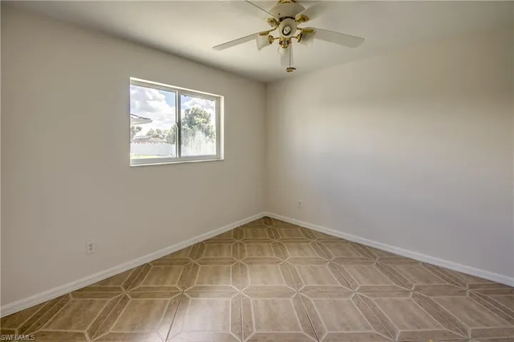 Spare room with ceiling fan and baseboards