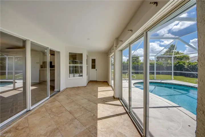 Unfurnished sunroom featuring a pool and a patio area