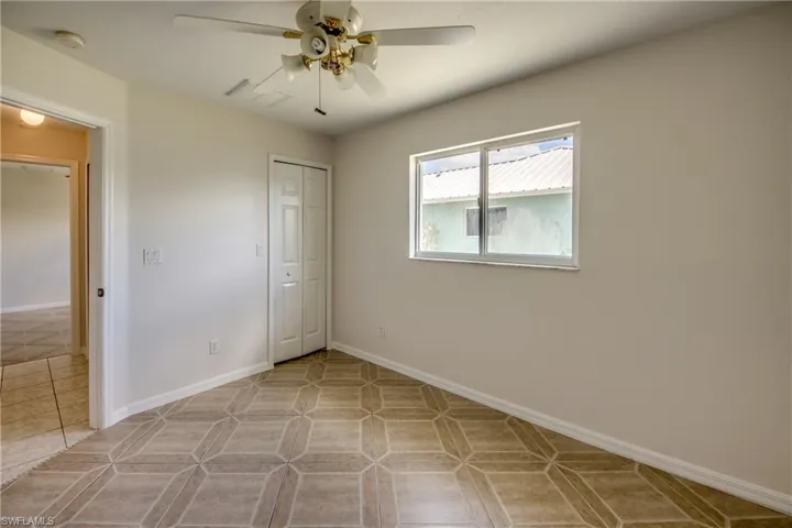Unfurnished bedroom with a closet, ceiling fan, and light tile patterned floors