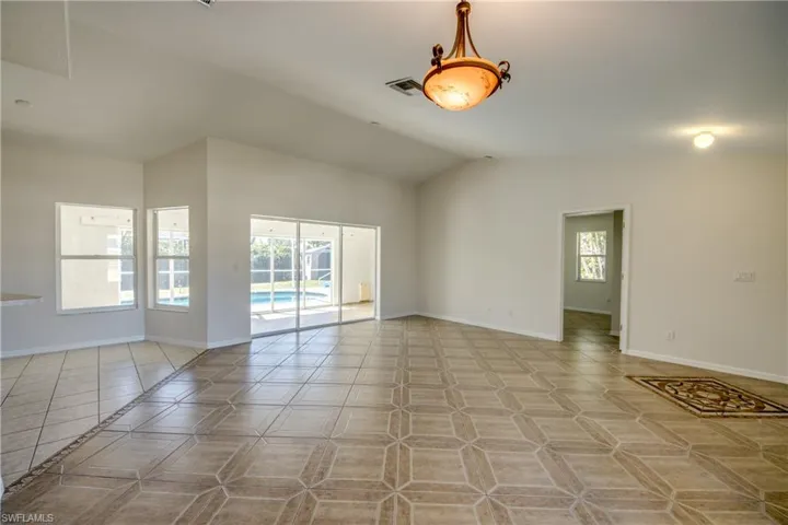 Spare room featuring baseboards and lofted ceiling