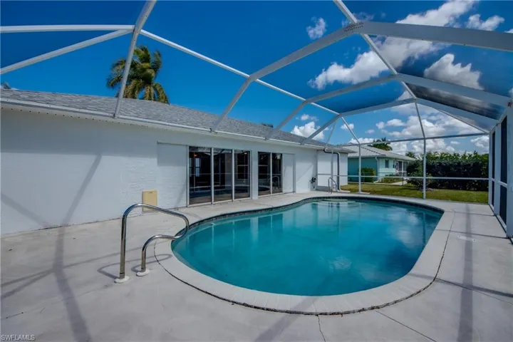 Swimming pool with a sunroom, a patio, and glass enclosure