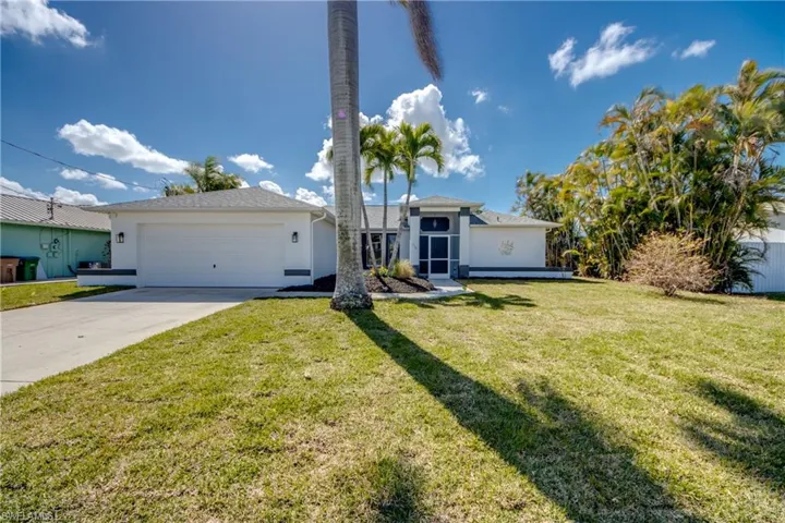 Ranch-style house featuring an attached garage, concrete driveway, a front yard, and stucco siding