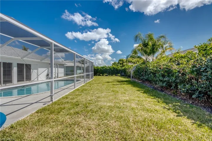 View of grassy yard featuring a sunroom, an outdoor pool, a lanai, and a patio