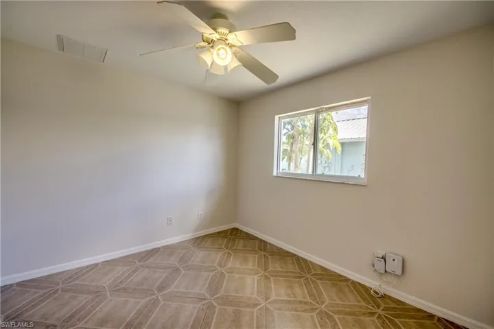 Unfurnished room with ceiling fan and baseboards